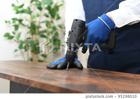 一個穿著年輕圍裙的年輕人在做 DIY 95298010