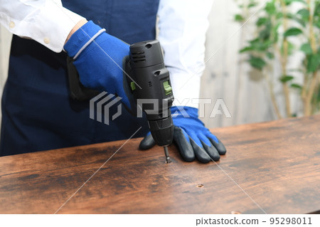 一個穿著年輕圍裙的年輕人在做 DIY 一個穿著年輕圍裙的年輕人在做 DIY 95298011