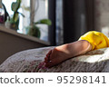 Bare feet in the bed in early morning in the sun 95298141
