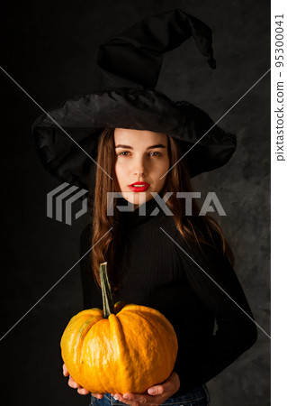 Beautiful smiling witch with pumpkin Beautiful smiling witch with pumpkin 95300041