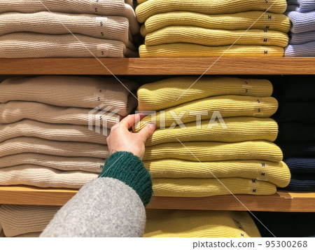 Woman's hand chooses a sweater for the winter 95300268