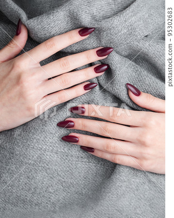 Hands of a young woman with dark red manicure on nails 95302683