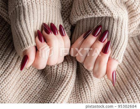 Hands of a young woman with dark red manicure on nails 95302684