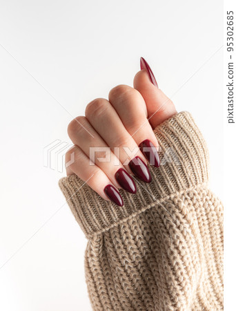 Hands of a young woman with dark red manicure on nails 95302685