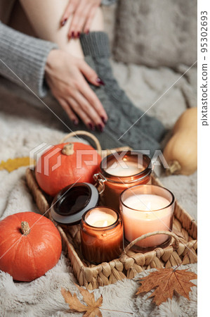 A girl in a sweater and knitted socks sits on a blanket 95302693