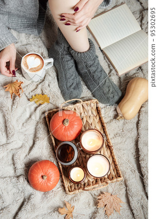 A girl in a sweater and knitted socks sits on a blanket A girl in a sweater and knitted socks sits on a blanket 95302695