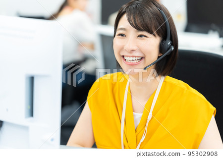 Young business woman working in a call center 95302908