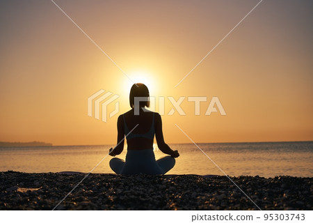 Silhouette young woman practicing yoga on the beach at sunset, Karon Beach ,Phuket ,Thailand. For Silhouette young woman practicing yoga on the beach at sunset, Karon Beach ,Phuket ,Thailand. For 95303743