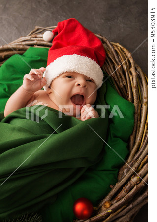 Cheerful newborn boy in a Santa hat Cheerful newborn boy in a Santa hat 95303915