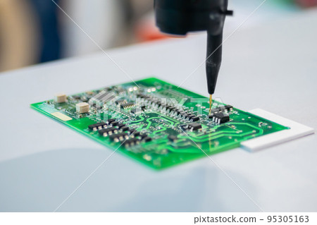 Automatic manipulator with dispenser needle during work with SMT pcb - close up 95305163
