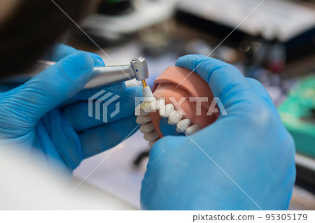 Dental technician working with dental prosthetics - close up view 95305179