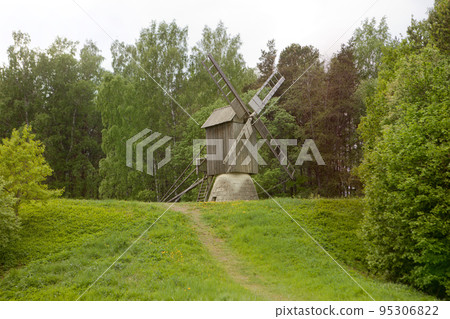 Wooden windmill on autumn forest hill. Timber construction - wildmill 95306822