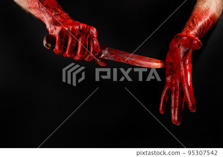A faceless man cuts his hand covered in blood. Black background. A faceless man cuts his hand covered in blood. Black background. 95307542