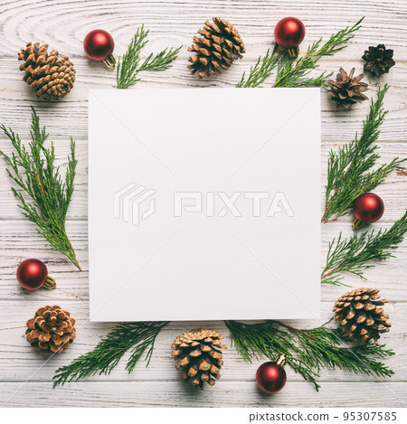 Flat lay Christmas composition. square Paper blank, pine tree branches, christmas decorations on Colored background. Top view, copy space for text 95307585