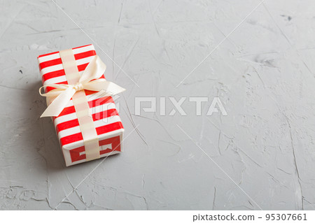 Wrapped christmas or other holiday handmade present in paper with colored ribbon. Present box, decoration of gift on table, top view with copy space Wrapped christmas or other holiday handmade present in paper with colored ribbon. Present box, decoration of gift on table, top view with copy space 95307661
