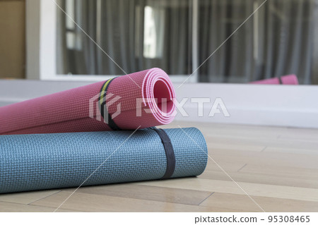 Yoga mats on the floor in the interior of the class gym for yoga, fitness and sports. Healthy lifestyle, meditation concept. Yoga mats on the floor in the interior of the class gym for yoga, fitness and sports. Healthy lifestyle, meditation concept. 95308465