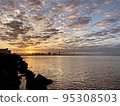 海岸上的日落和日出，遠處可以看到建築物 95308503