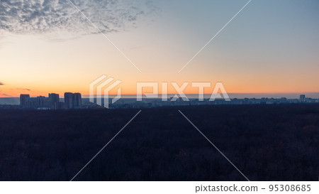 Aerial dark city and forest, epic sunset evening Aerial dark city and forest, epic sunset evening 95308685