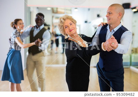 Man and senior woman dancing waltz in studio Man and senior woman dancing waltz in studio 95309482