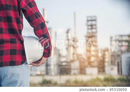 Refinery woman engineer oil industry hands hold worker helmet hard hat. Refinery industry engineering. Engineer woman hands holding hardhat white work helmet hard hat for Construction Engineering 95310050