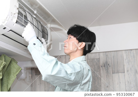 Male worker investigating home air conditioner Male worker investigating home air conditioner 95310067