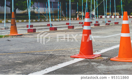 Driving test and training area with simulate test for driving license. Driving school practice traffic area with pole signs and orange cones and road signs for safety on concrete road. Selective 95311860