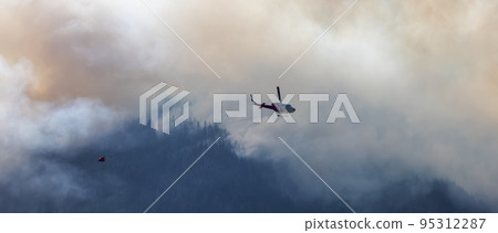 Wildfire Service Helicopter flying over BC Forest Fire and Smoke on the mountain near Hope 95312287