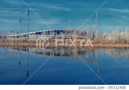 Soccer stadium near the riverbank. Reflection, autumn, dramatic sky. Soccer stadium near the riverbank. Reflection, autumn, dramatic sky. 95312486