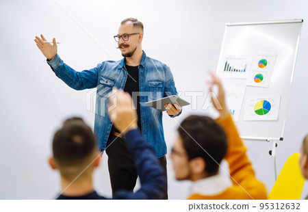 Male business coach speaker giving flipchart presentation Male business coach speaker giving flipchart presentation 95312632