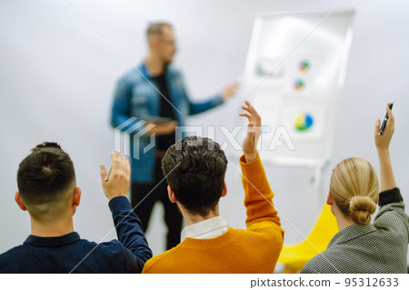 Business people raising hand up to ask question with speaker Business people raising hand up to ask question with speaker 95312633