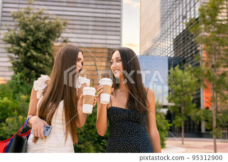 Women drinking coffee after shopping in city Women drinking coffee after shopping in city 95312900