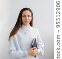 Low angle of young pretty bussines woman standing with arms crossed isolated on white background 95312906