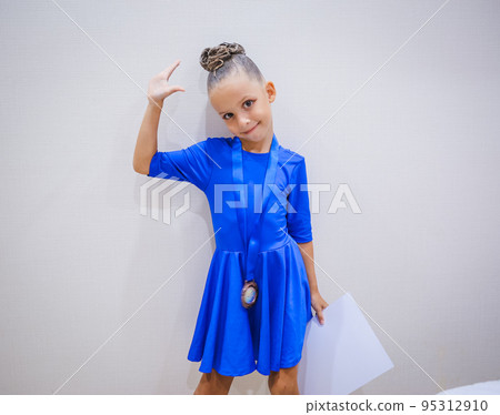 Beautiful happy smiling gymnast and dance girl in sportswear dress showing her medals. Beautiful happy smiling gymnast and dance girl in sportswear dress showing her medals. 95312910
