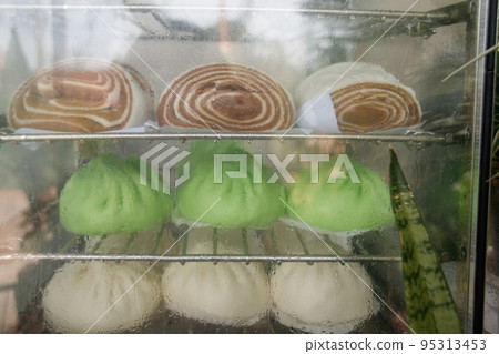 Healthy vegan steamed red bean buns or Dou Sha Bao inside a glass display shelf Healthy vegan steamed red bean buns or Dou Sha Bao inside a glass display shelf 95313453