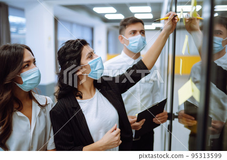 Business team people in protective face mask brainstorm on corporate project together write strategy Business team people in protective face mask brainstorm on corporate project together write strategy 95313599