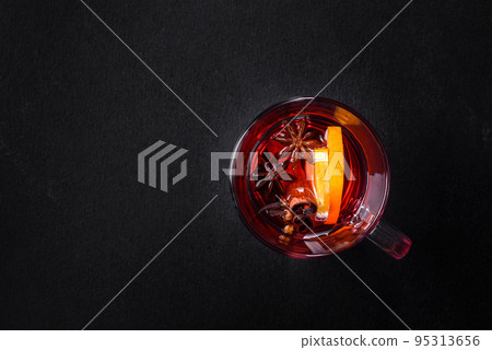 Christmas mulled red wine with spices and fruits on a concrete table Christmas mulled red wine with spices and fruits on a concrete table 95313656