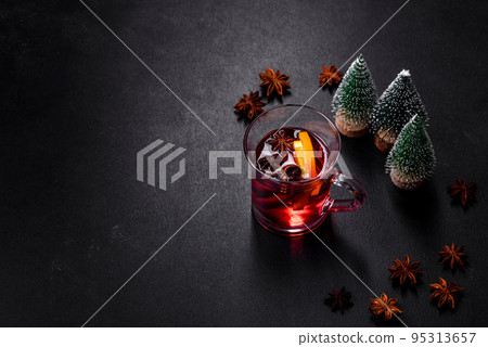 Christmas mulled red wine with spices and fruits on a concrete table Christmas mulled red wine with spices and fruits on a concrete table 95313657