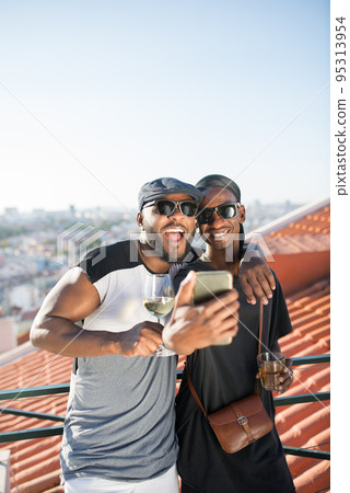 Portrait of happy African gay couple taking selfie together Portrait of happy African gay couple taking selfie together 95313954