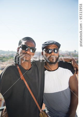 Portrait of happy African gay couple posing on roof top Portrait of happy African gay couple posing on roof top 95313958
