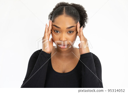 Portrait of tired young woman rubbing temples 95314052