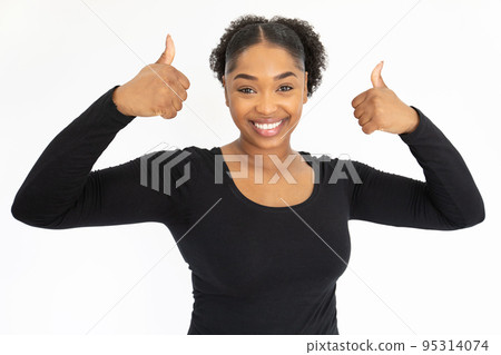 Portrait of happy young woman making thumbs up 95314074