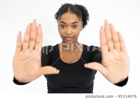Portrait of confident young woman making stop or frame gesture 95314076