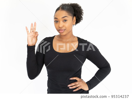 Portrait of positive young woman making ok gesture 95314237
