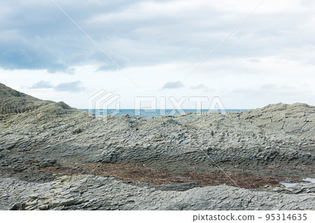 rocky seashore made of columnar granite, hardened lava, resembling scales or cobblestone pavement, coast of Kunashir island rocky seashore made of columnar granite, hardened lava, resembling scales or cobblestone pavement, coast of Kunashir island 95314635