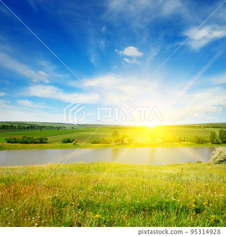 Meadow, lake, agricultural fields and sunrise on blue sky. Meadow, lake, agricultural fields and sunrise on blue sky. 95314928