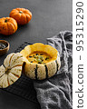 Pumpkin cream soup served in a squash with seeds 95315290