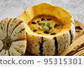 Pumpkin cream soup served in a squash with seeds 95315301