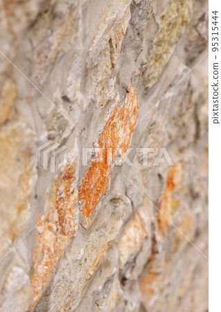 Stone wall. Uneven rough rock surface. Abstract brown background. Vertical view Stone wall. Uneven rough rock surface. Abstract brown background. Vertical view 95315444