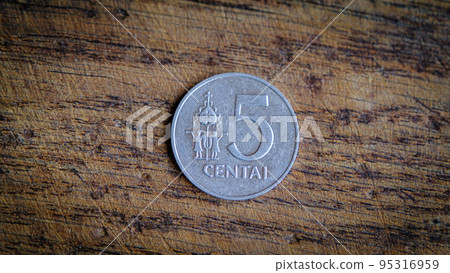 Five Lithuanian cents coin isolated on wooden background. Five Lithuanian cents coin isolated on wooden background. 95316959