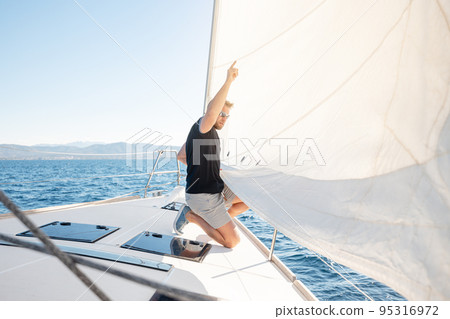 Man setting sail on his boat Man setting sail on his boat 95316972